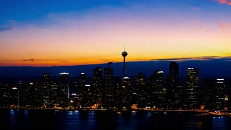 city skyline lights illuminating as the sun sets below the horizon, creating a vibrant urban evening atmosphere