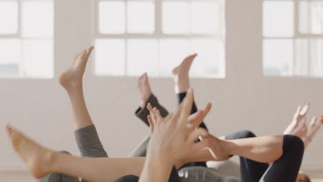 yoga class of healthy pregnant women practicing stretches laying on exercise mat enjoying group physical fitness workout in studio