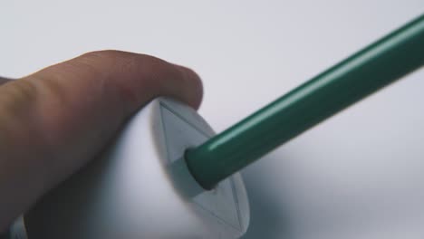 man sharpens pencil on light background extreme close view