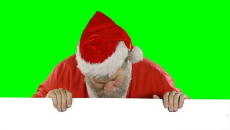 Surprised-santa-claus-hiding-behind-green-screen