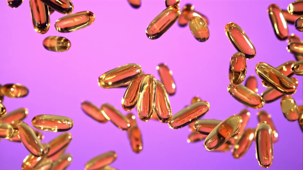 Cápsulas Softgel Douradas Flutuando em um Fundo Roxo