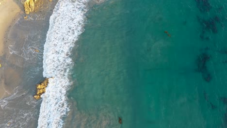 toma de drones ariel de 4k de aguas cristalinas a lo largo de la costa de una hermosa playa soleada