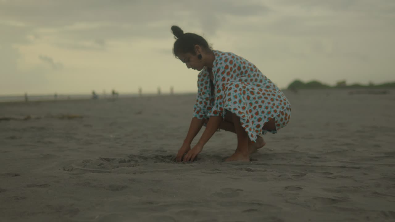 Full-body shot of a woman's joyful interaction with the beach's soft sand