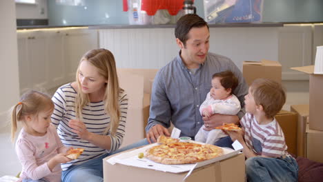 familia celebrando el traslado a una nueva casa con pizza