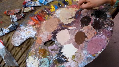 mixing flesh tones on palette with spatula