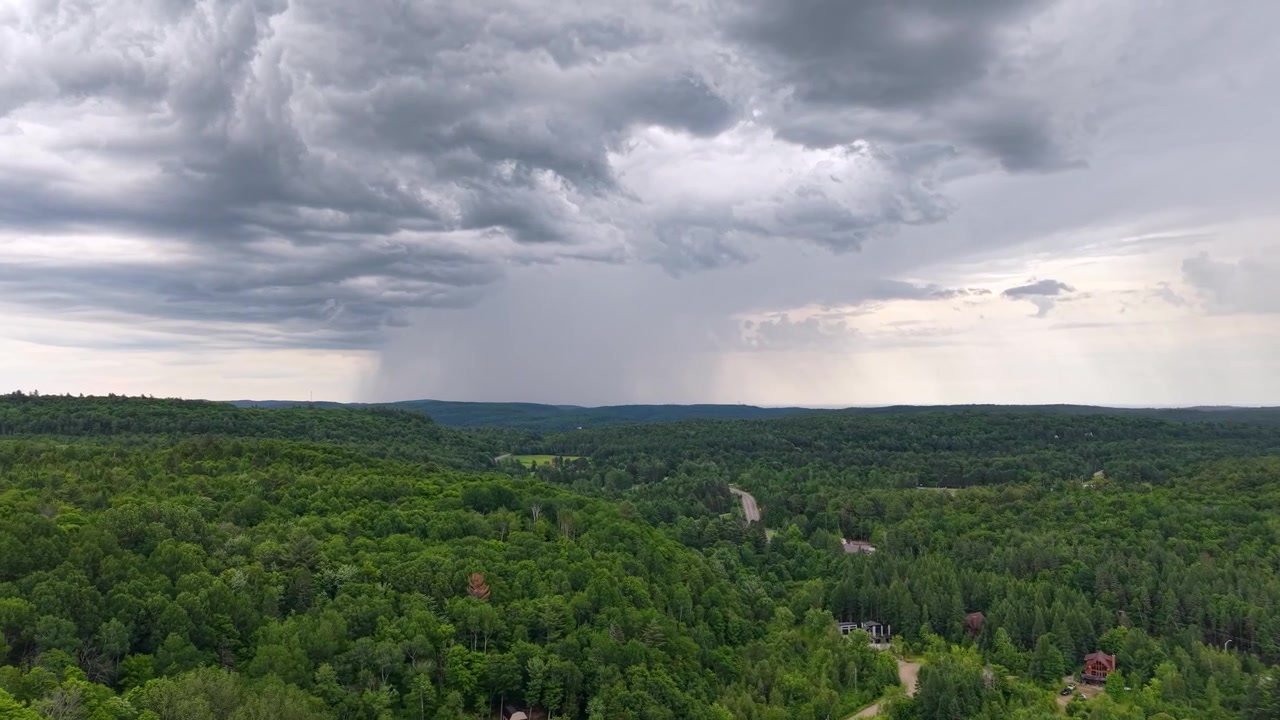 Fjern luftfoto af regnskyer, der strømmer over tæt skov i Chibougamau, Quebec, Canada