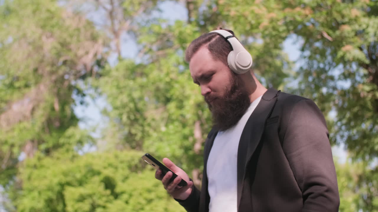 Bearded Man Enjoying Music and Walking Outdoors