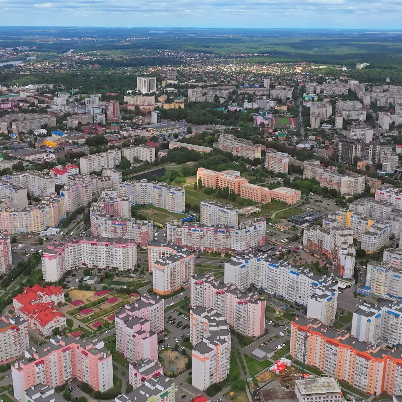 Modern building of residential complex. Aerial drone view over apartment blocks in city. Construction site shot from above. Aerial view of new residential building under construction