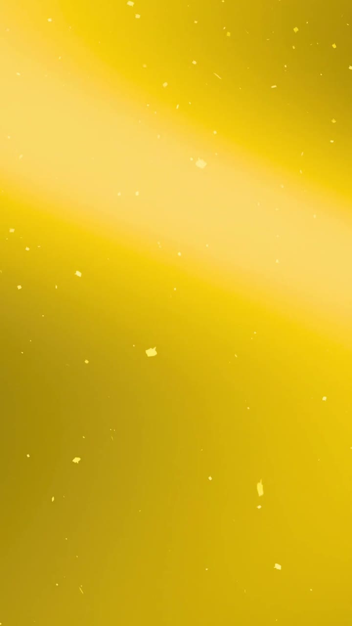 Serpihan Emas Berkilauan Mengambang di Latar Belakang Gradien Kuning Cerah.