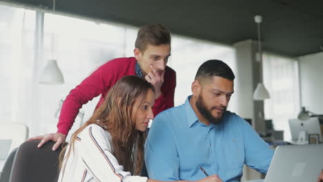 Thoughtful-business-team-working-with-laptop-together.