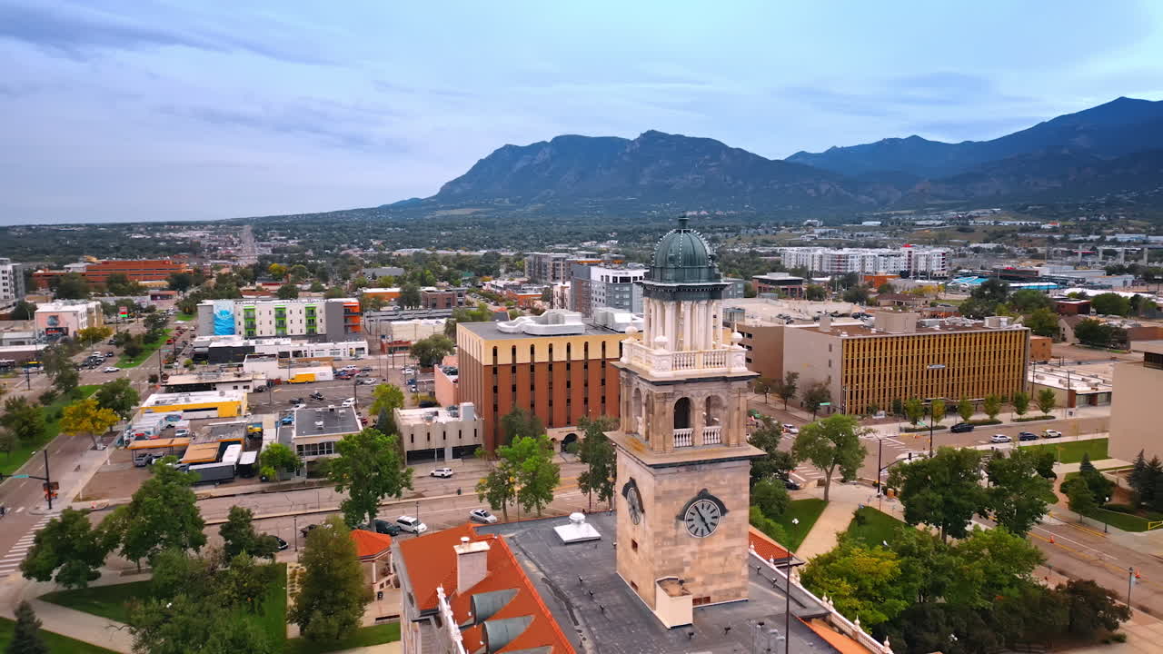 Century old clock tower of the Colorado Springs City Hall. Aerial view on the cityscape surrounded by the mountains