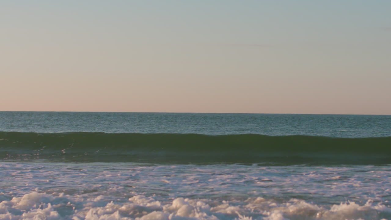 포르투갈 루즈에서 잔잔한 일출 동안 부서지는 작은 파도