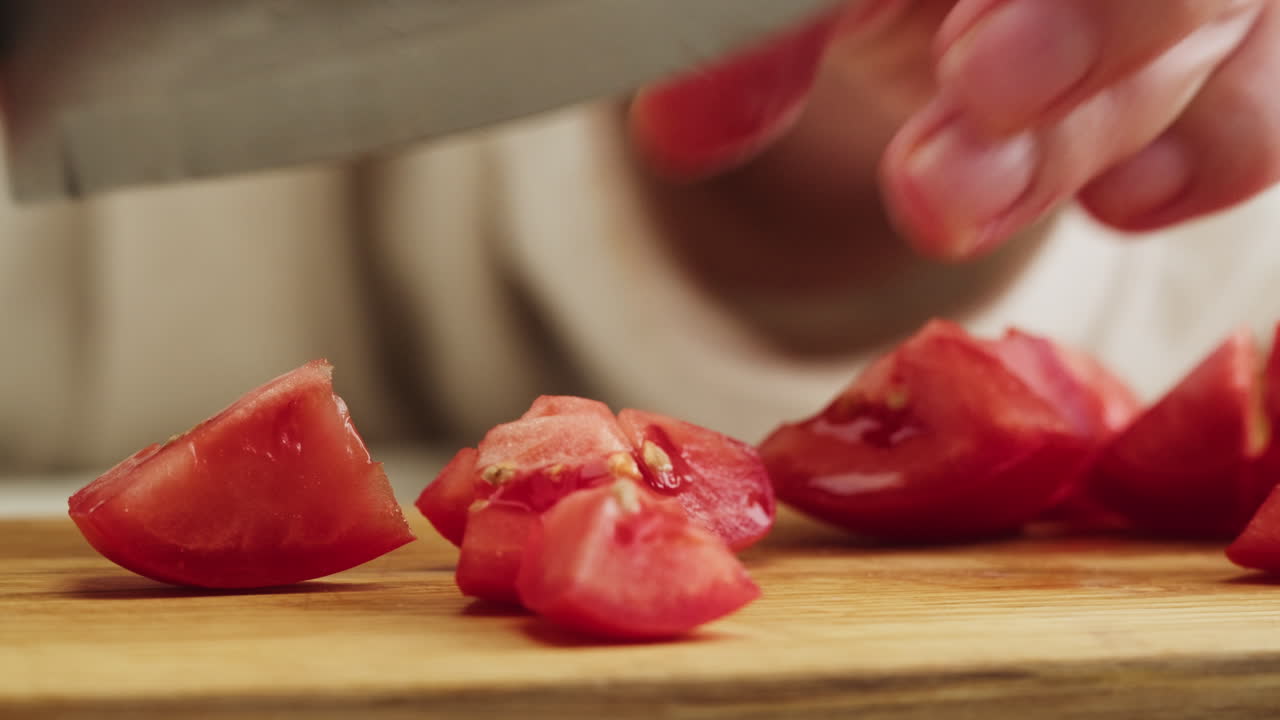 Close Up of Hands Slicing Fresh Red Tomato on a Cutting Board