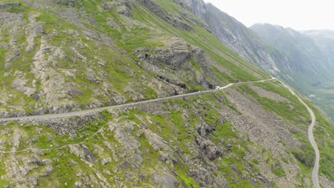 distant view of a white vehicle traveling on the trollstigen mountain pass in more og romsdal, norway