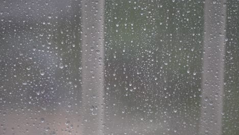 Regentropfen-Auf-Dem-Verschwommenen-Fensterglas-An-Einem-Regnerischen-Tag---Nahaufnahme