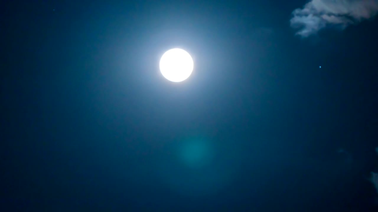 Time lapse of super moon with cloudy night sky and shiny stars background.