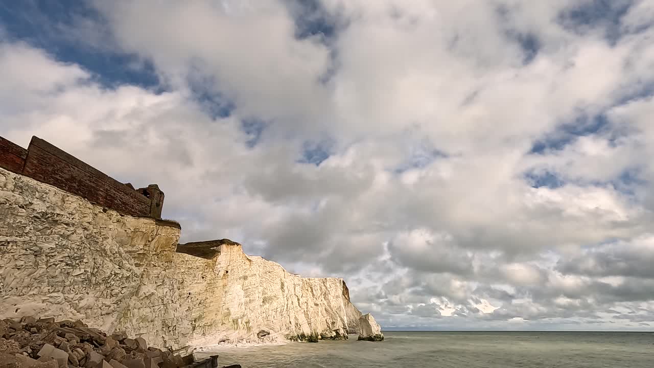 구름이 가득한 하늘 아래 바다와 만나는 도자기 절벽