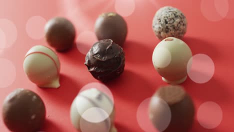 animation of light over chocolate pralines on red surface