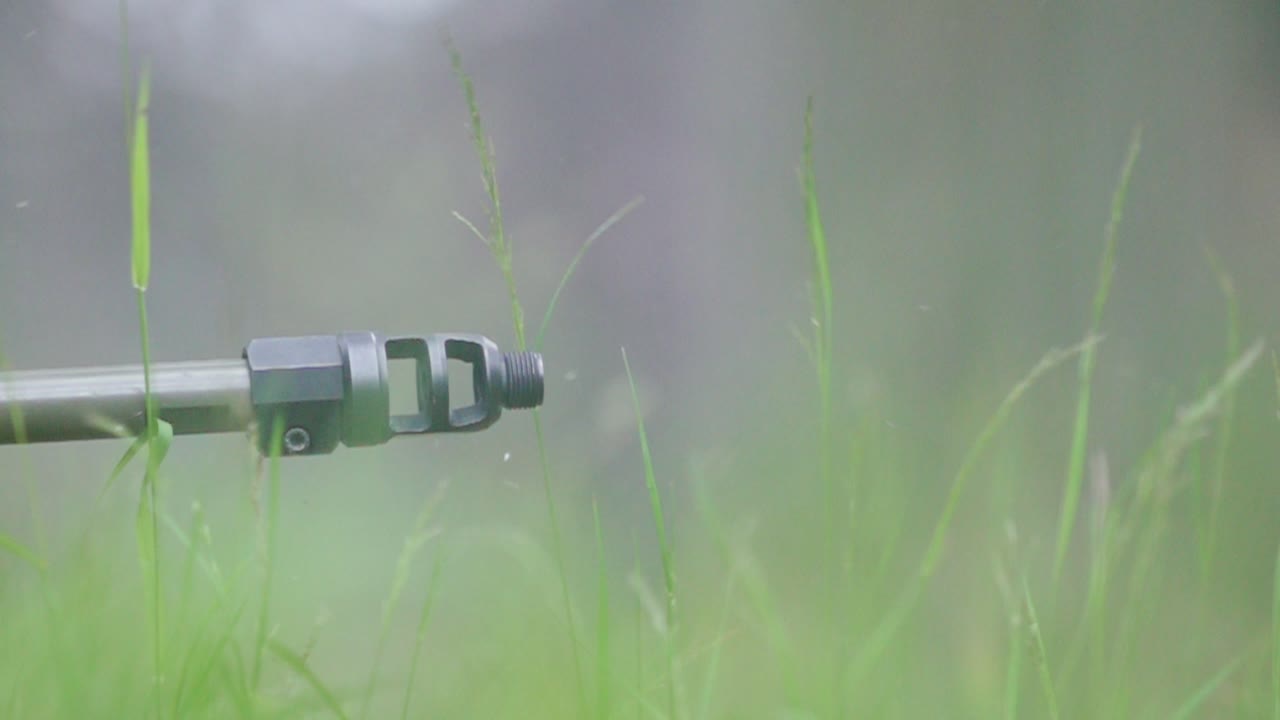 Energy ripple from sniper shot in forest moves grass in slow cinematic motion