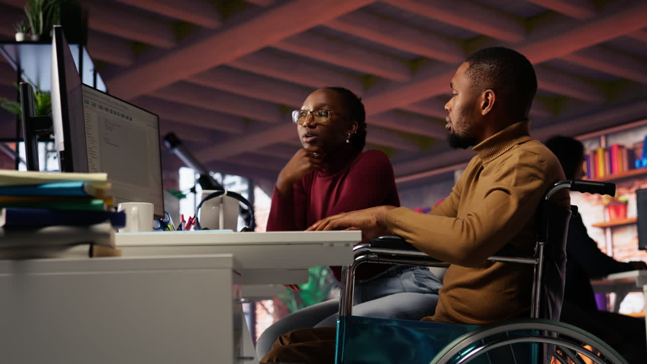 gerente que viene a una startup inclusiva empleado en silla de ruedas para ofrecer ayuda