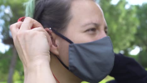 movimiento dinámico de mujer mirando el móvil, poniéndose los auriculares y luego tocando la pantalla