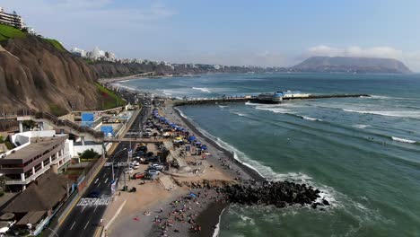 Video-Panorámico-Aéreo-Diurno-De-4k-De-La-Playa-Makaha-En-Miraflores-Y-La-Rosa-Nautica-En-La-Costa-De-Lima,-Perú