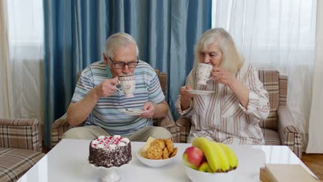 Pareja-Familiar-Madura-Abuelo,-Abuela-Relajándose-En-Un-Acogedor-Sofá-Disfrutando-De-Una-Conversación-En-Casa