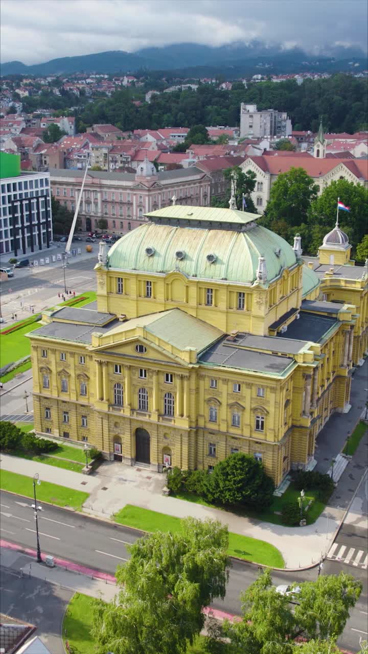 Orbital aerial circling the Croatian National Theatre in Zagreb, Croatia, showcasing its grand architecture, ornate details, and elegant façade