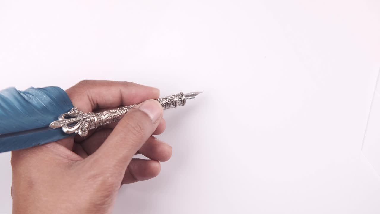 털 을 가진 빈티지 펜 을 들고 있는 손