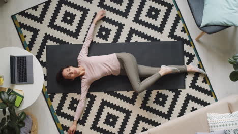 Woman Doing Stretching Exercise on Mat at Home