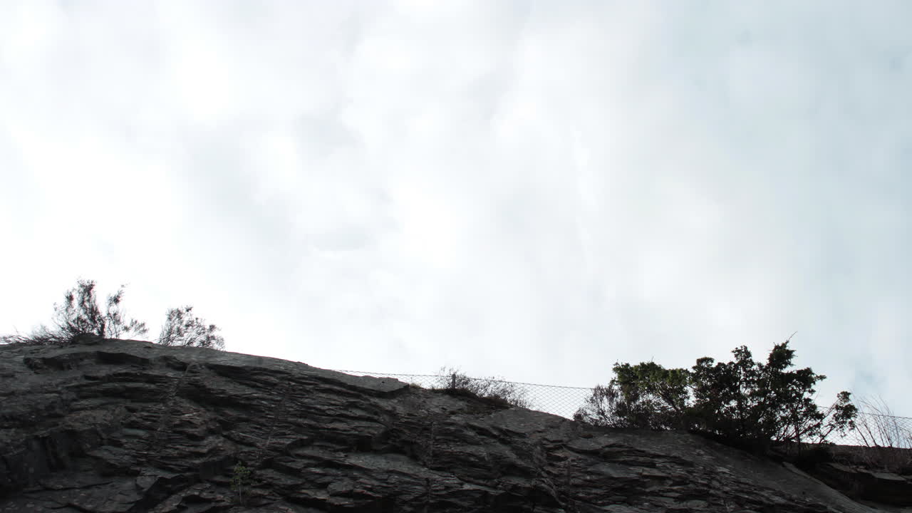 돌 언덕의 시간 경과 보기와 구름이 하늘에서 움직이고 있습니다.