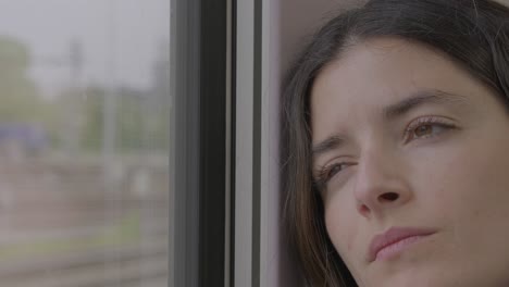 thoughtful young woman gazing through train window