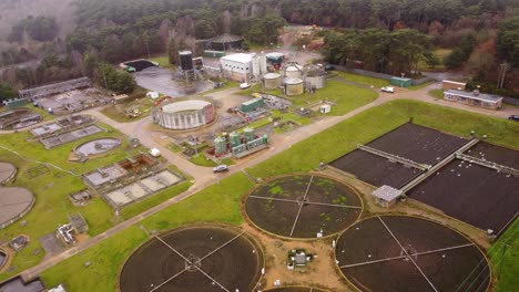 industrial wastewater treatment plant factory into forest at thetford, norfolk - aerial drone backward shot : forest destruction concept