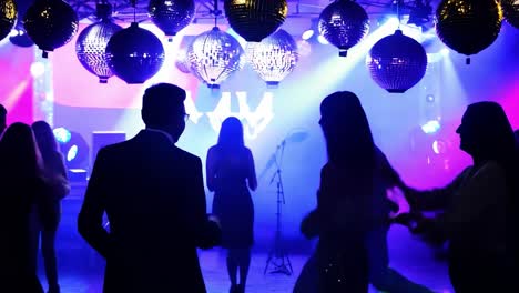 silhouettes of people dancing at a nightclub