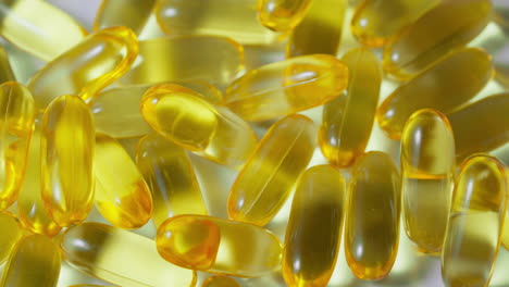 Eine-ältere-Männliche-Arzthand-Nimmt-Eine-Gelbe-Omega-3-Pille-Auf