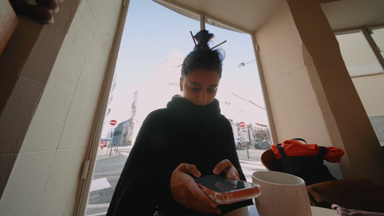 Woman using phone in cafe