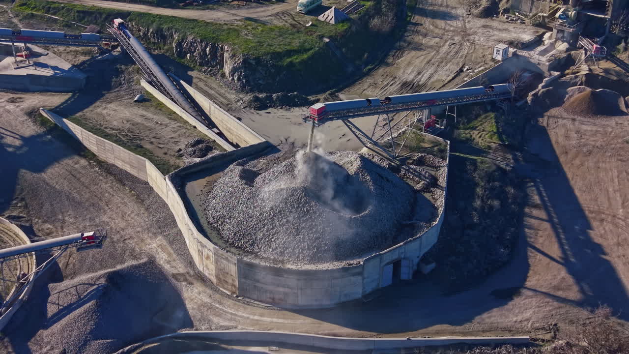 Lavori di costruzione in un sito di lavorazione della ghiaia con macchinari operativi sotto un cielo azzurro durante il giorno
