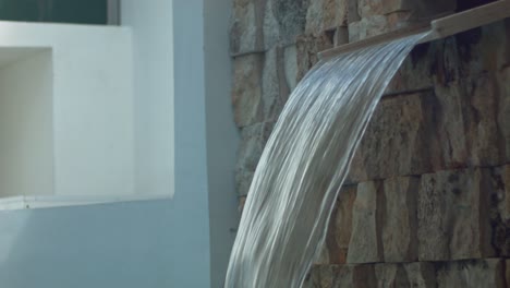 el accesorio de cascada de la piscina al aire libre fluye hacia el agua con una corriente pesada