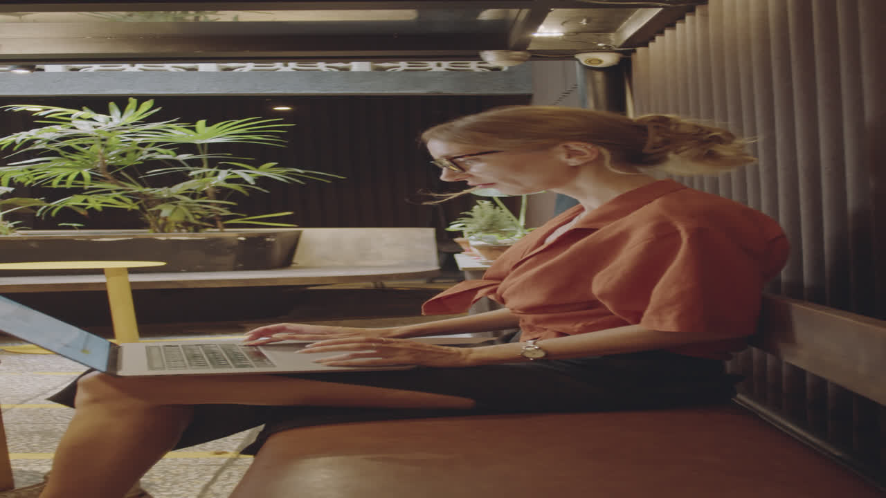 Young Woman Using on Laptop in Modern Cafe