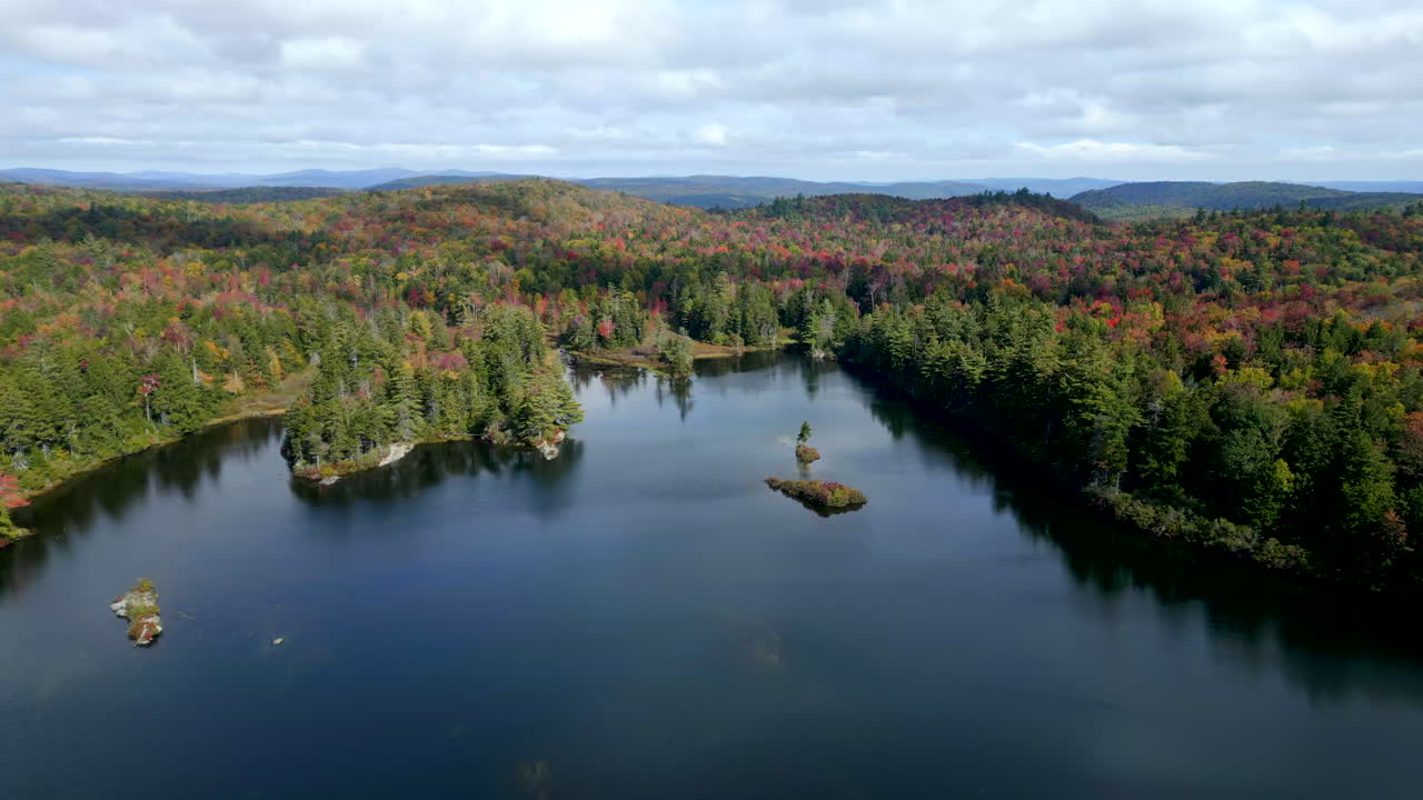 Aerial view of a serene lake surrounded by colorful autumn foliage