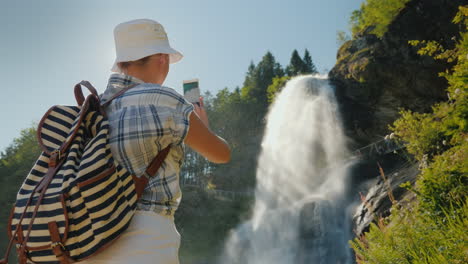 reiziger maakt foto's van majestueuze steinsdalsfossen is een waterval in het westen van noorwegen 4k video