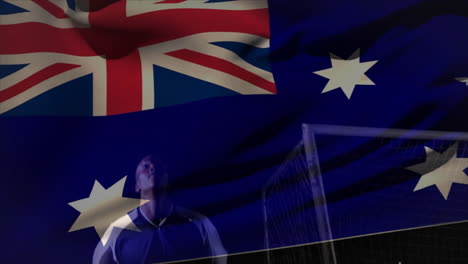 Waving Australian flag, soccer player standing near goalpost on field