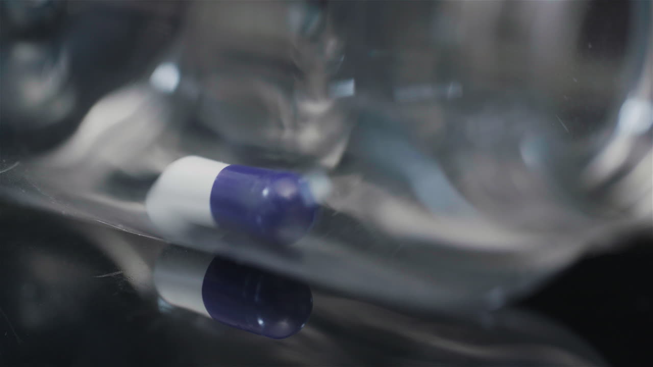 píldora médica única en botella pequeña girando sobre fondo negro 7