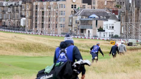 golfers walking on a green field