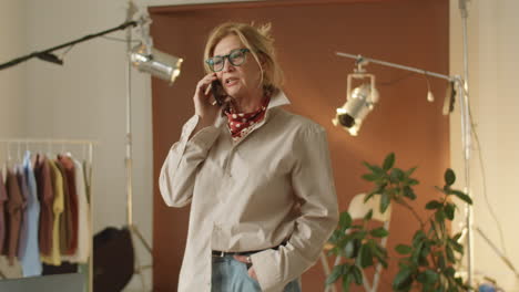 stylish mature woman having phone talk at work