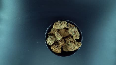 una grúa cinematográfica de arriba hacia abajo detallada suave zoom out movimiento tiro de una planta de cannabis, cepas híbridas de naranja, tipo indica, flor de marihuana crujiente, cámara lenta 120 fps, estudio led luces, soporte brillante
