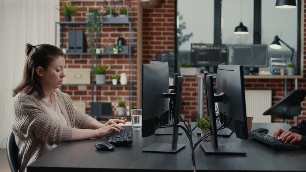 Software engineer typing source code on computer keyboard turning head and smiling