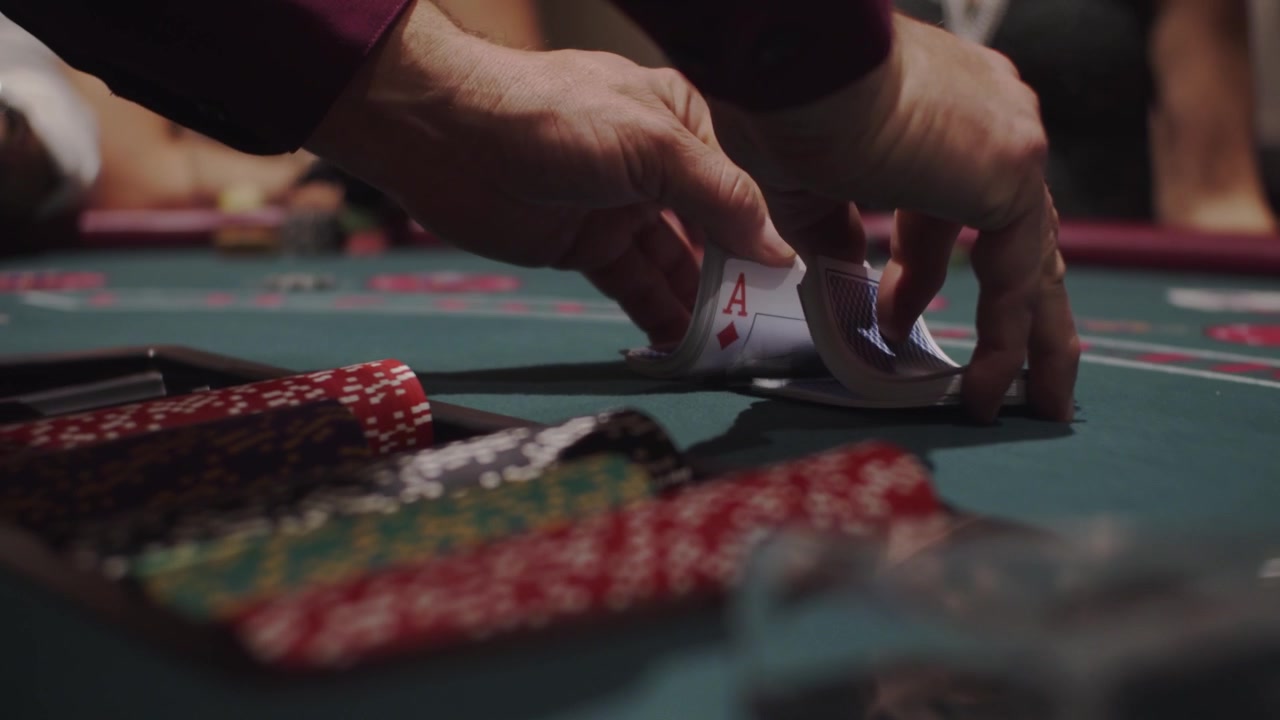 Croupier che mescola le carte per Blackjack o Catch 21 al tavolo del casinò al rallentatore