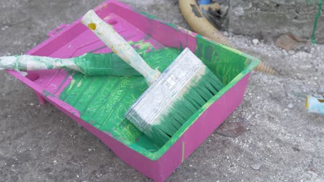 used painters tray with brushes covered in green paint
