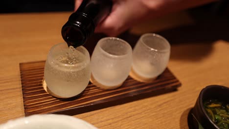 sequential pouring of a fizzy drink into multiple glasses